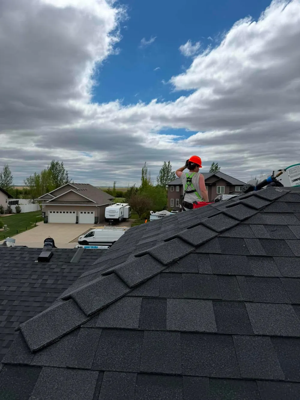 Finished ridge cap on black shingle roof installed in Regina Saskatchewan